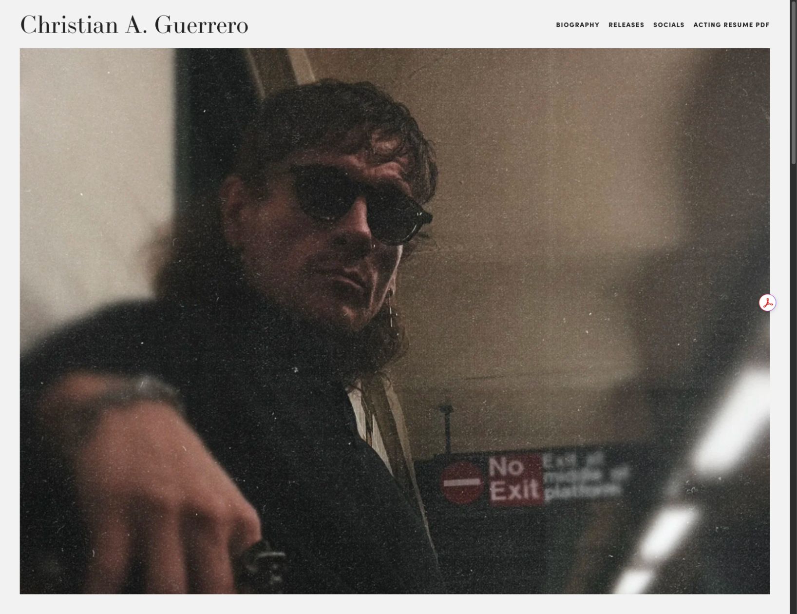 Christian A. Guerrero website with editorial typography and a full-width portrait photographed through a window